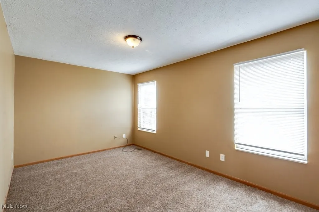 Spare room with a textured ceiling and carpet floors
