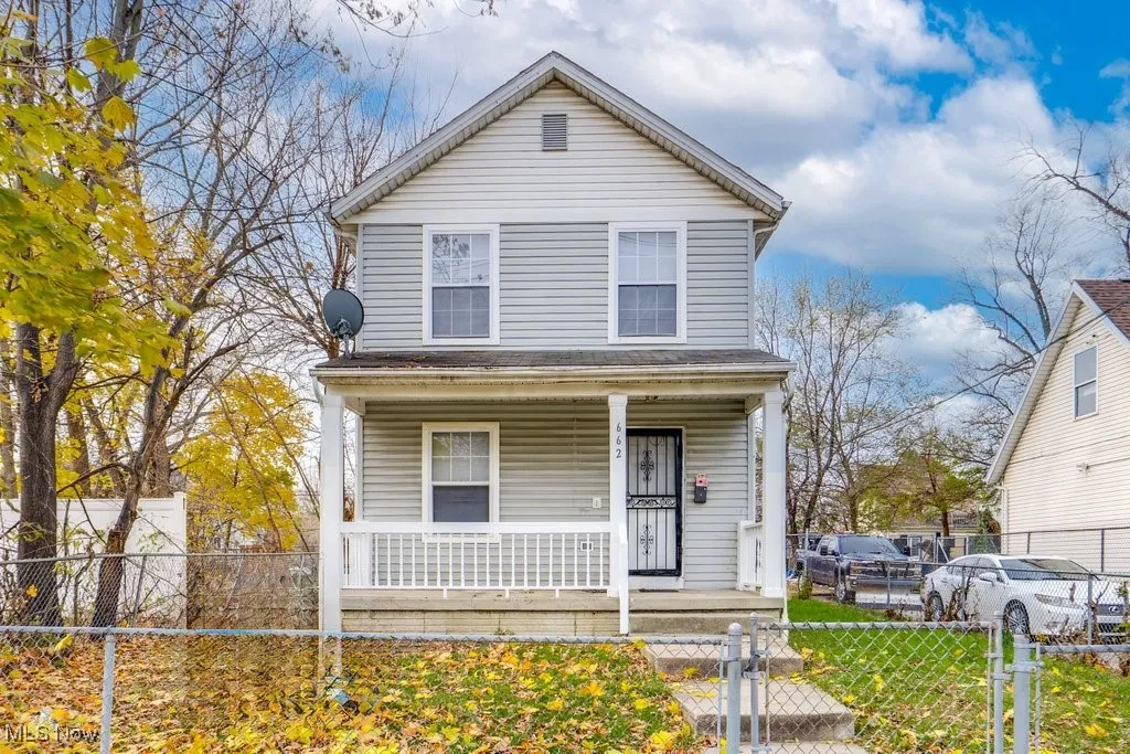 View of front of house with a porch, a fenced front yard, and a gate