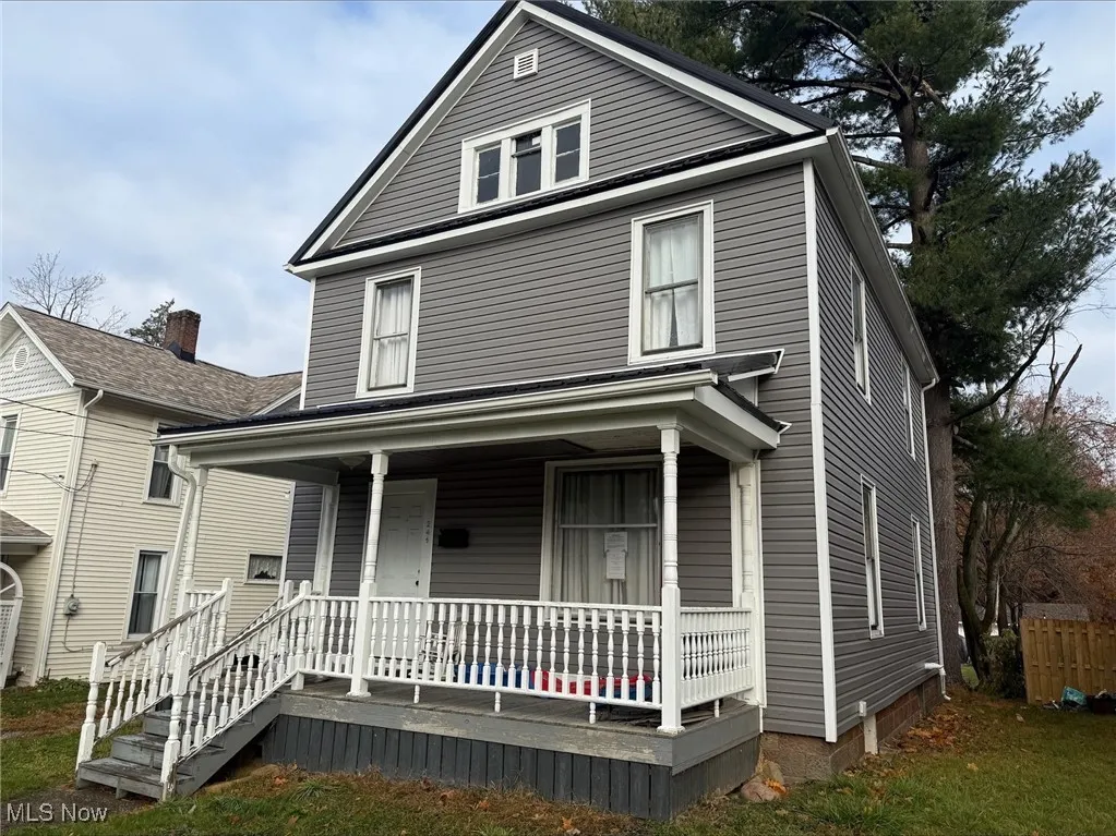 American foursquare style home featuring covered porch