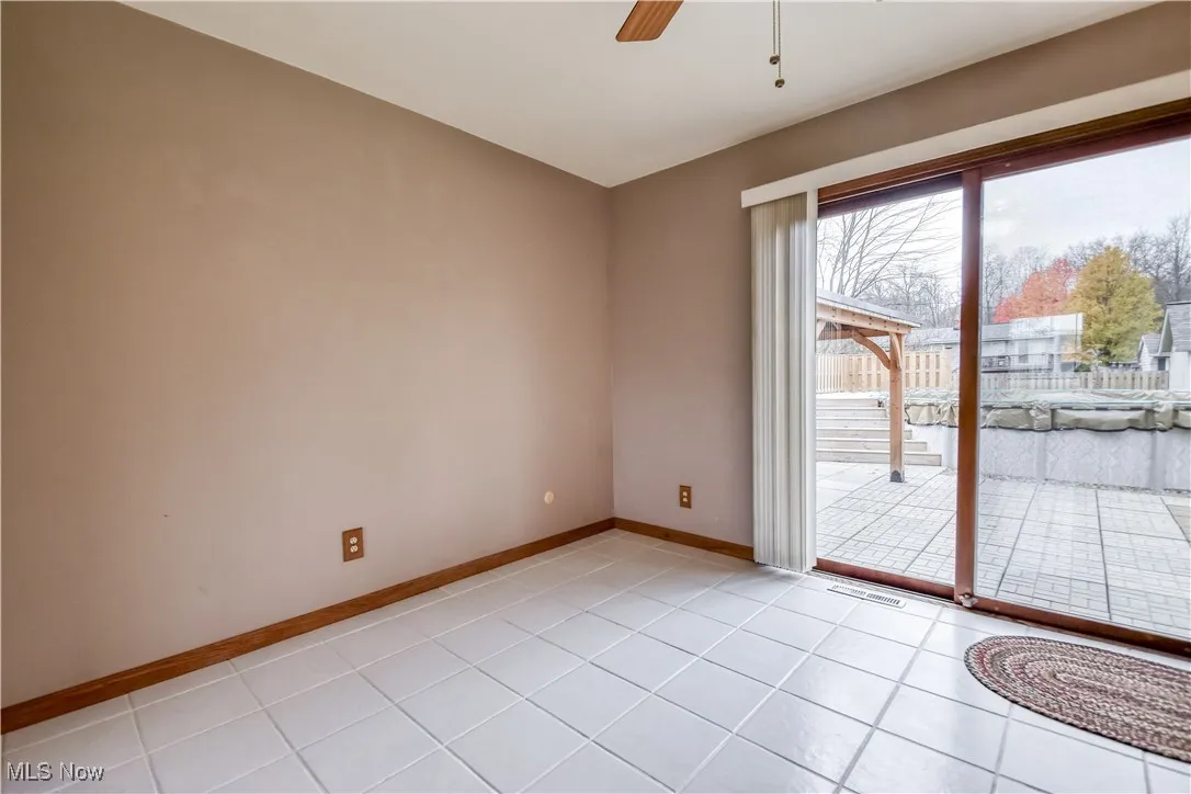 Spare room with ceiling fan and light tile patterned floors