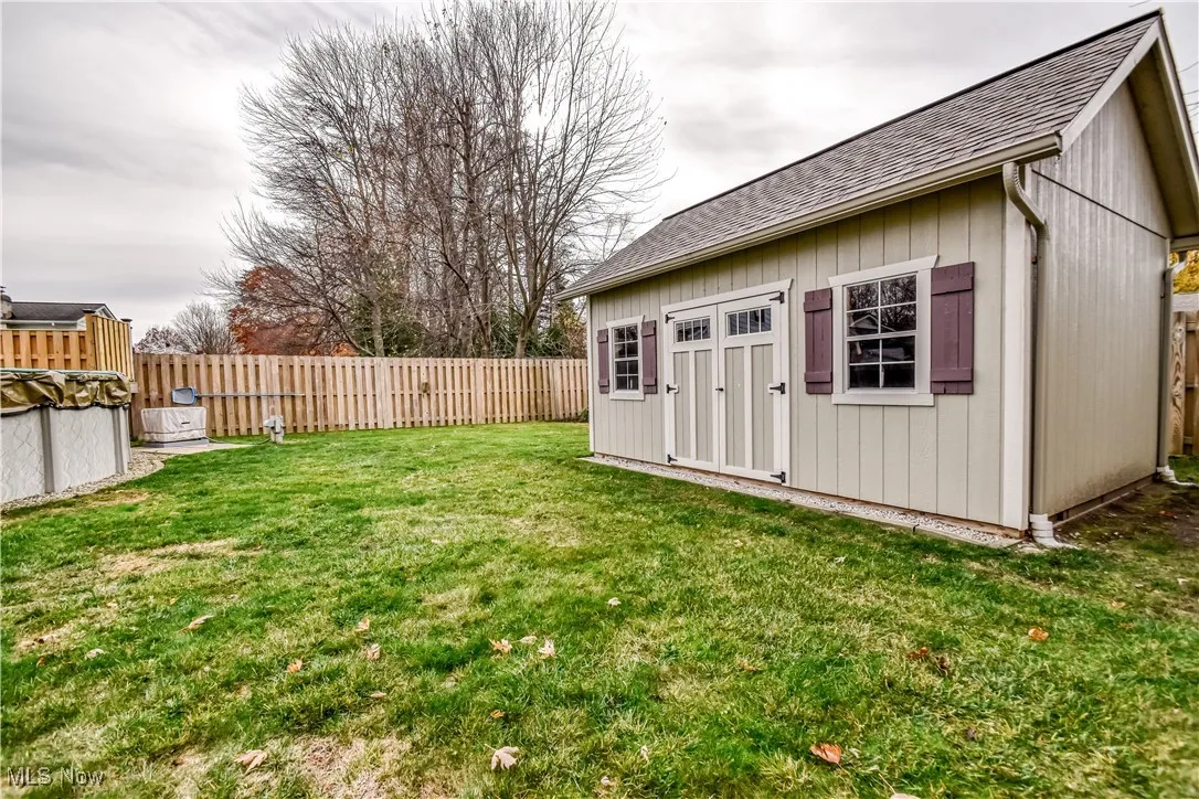 Fenced backyard featuring an outdoor structure