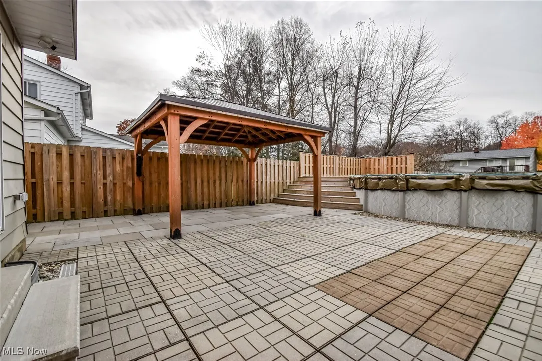 Fenced backyard featuring a patio area and a gazebo