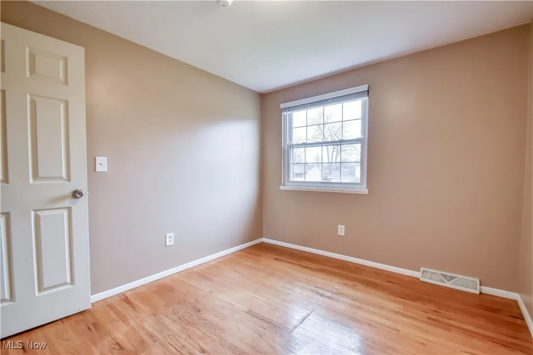 Spare room featuring baseboards and light wood finished floors