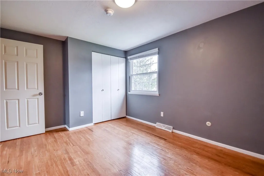 Unfurnished bedroom featuring light wood-type flooring and a closet