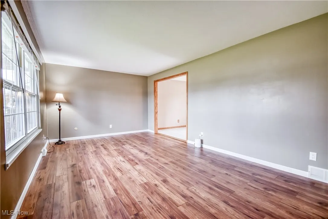 Spare room with wood-type flooring and baseboards