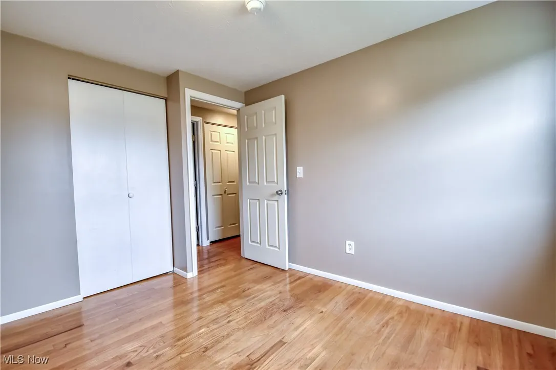 Unfurnished bedroom featuring light wood finished floors and a closet