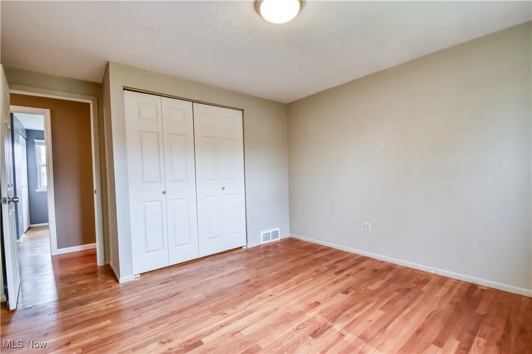 Unfurnished bedroom featuring light wood-style floors and a closet