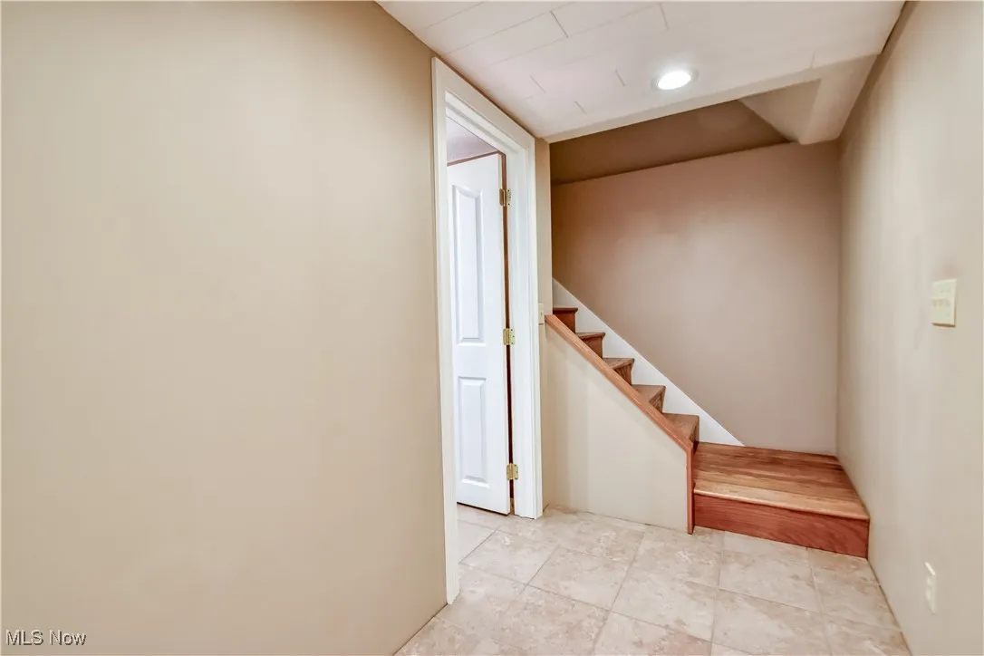 Stairs featuring tile patterned floors and recessed lighting