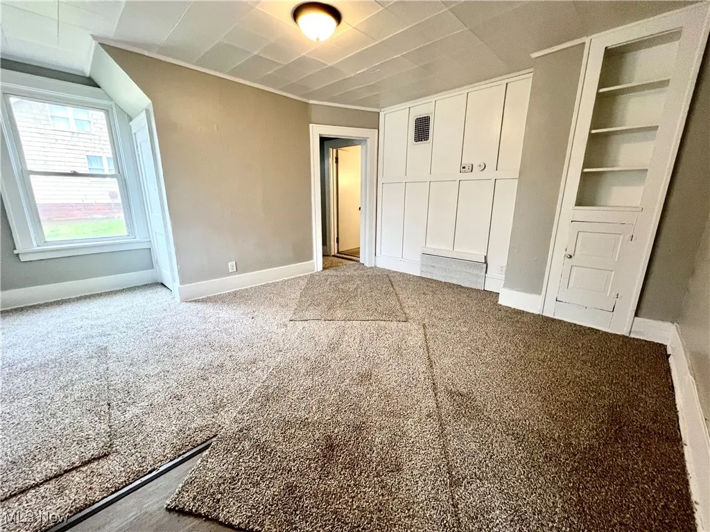Unfurnished bedroom with baseboards and light colored carpet