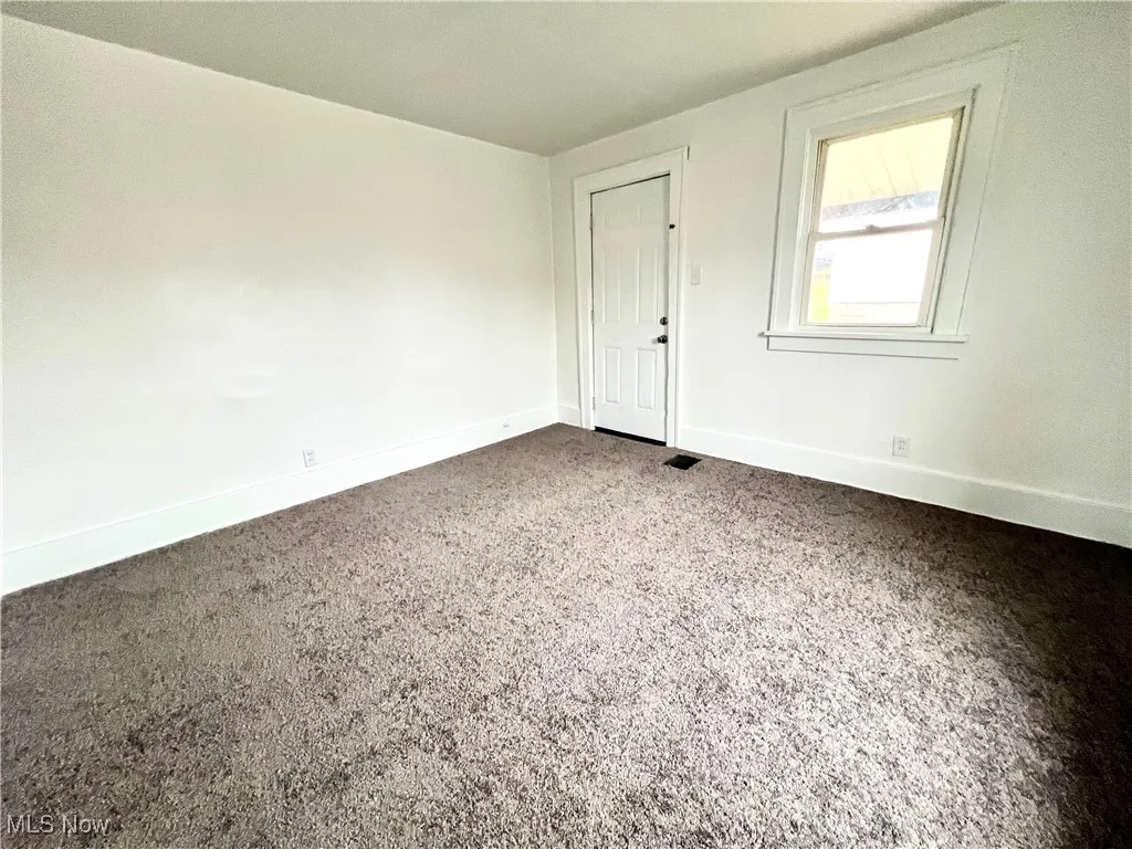 Unfurnished room with carpet floors and baseboards