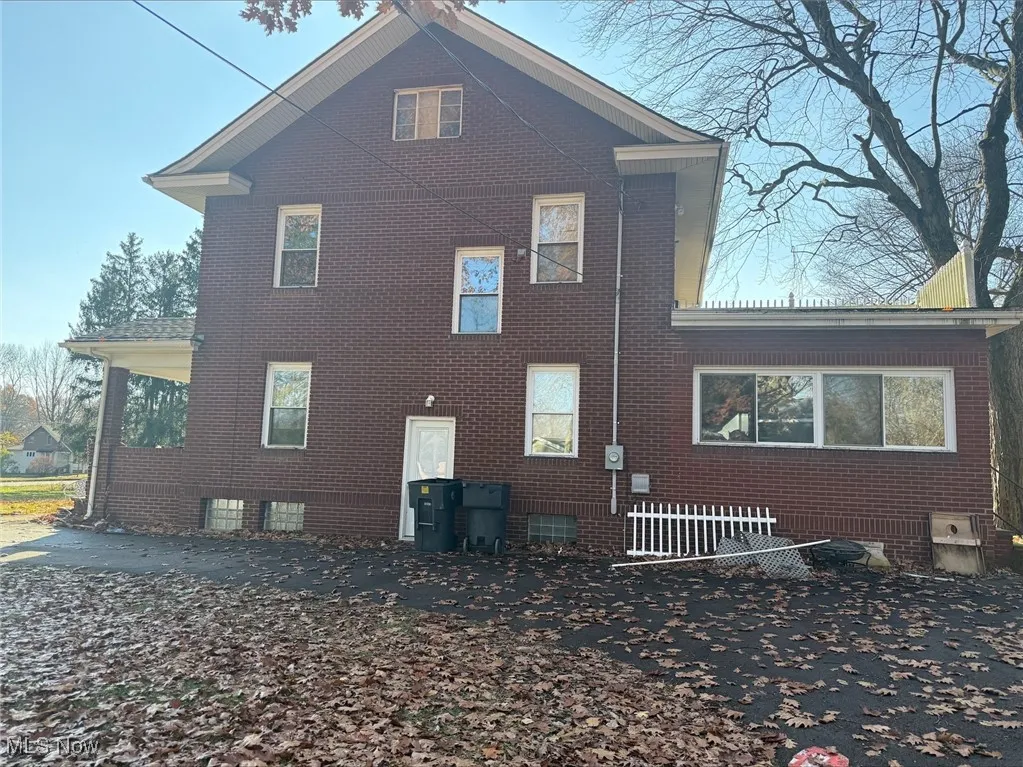 Rear view of property with brick siding