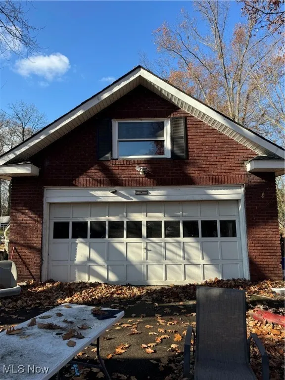View of property exterior with brick siding and a garage