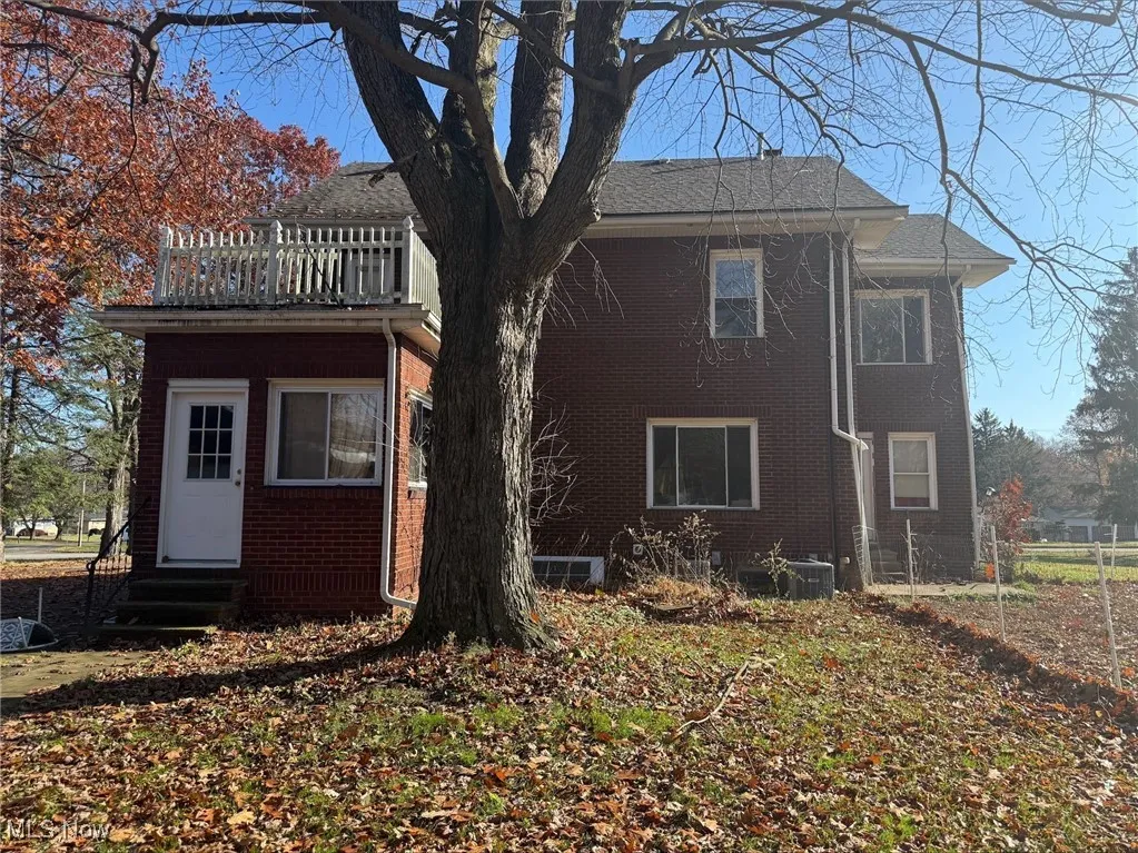 Back of property with brick siding and entry steps