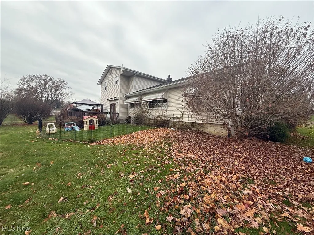 View of side of home with a yard and a chimney