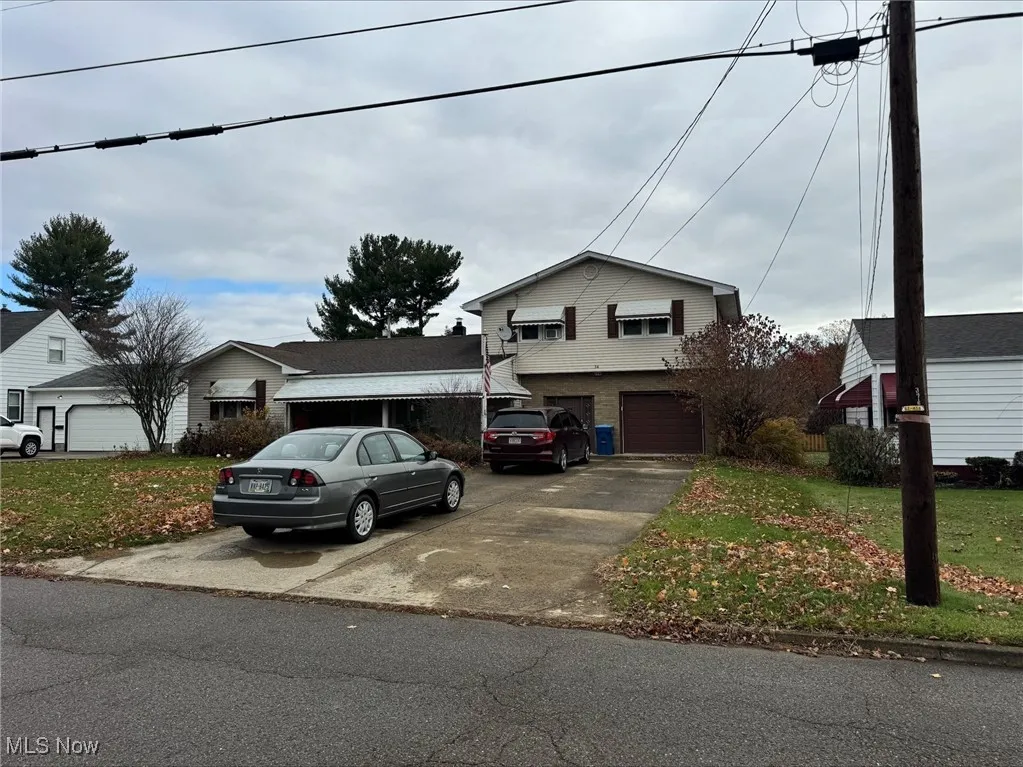 View of front facade with driveway, an attached garage, and a front yard