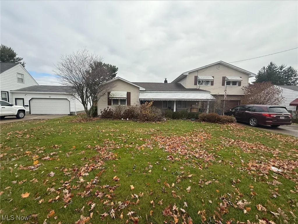 View of front of home featuring a garage, a front lawn, and driveway