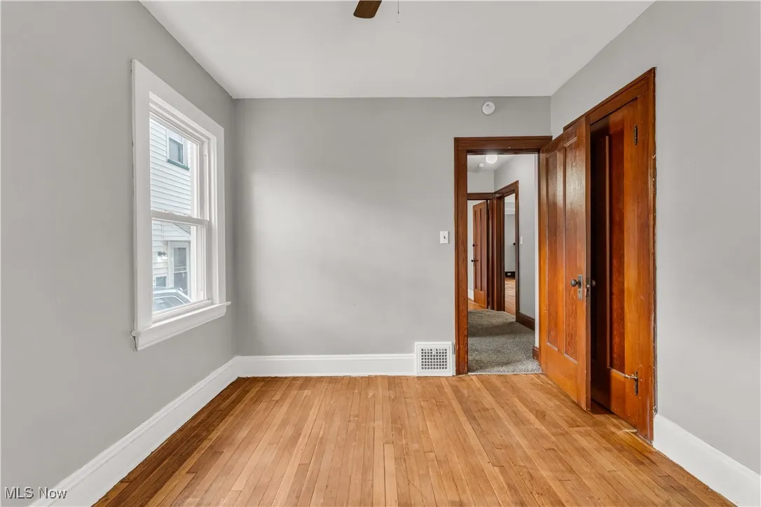 Empty room with light wood finished floors and a ceiling fan