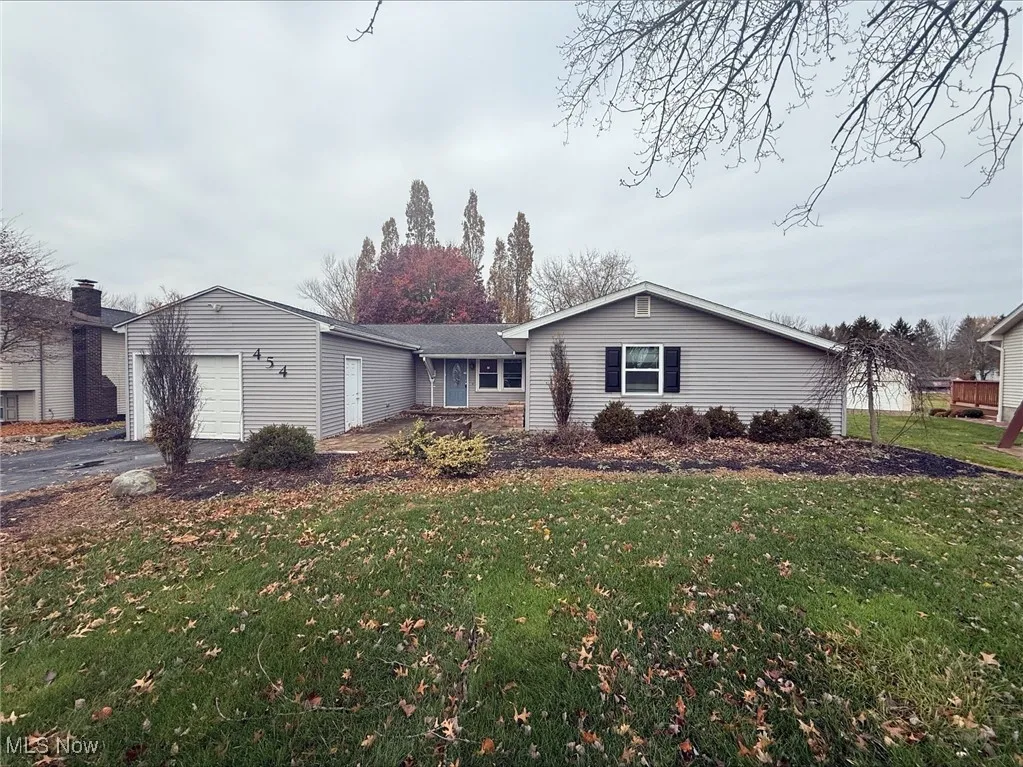 Ranch-style home with a front lawn, driveway, and a garage