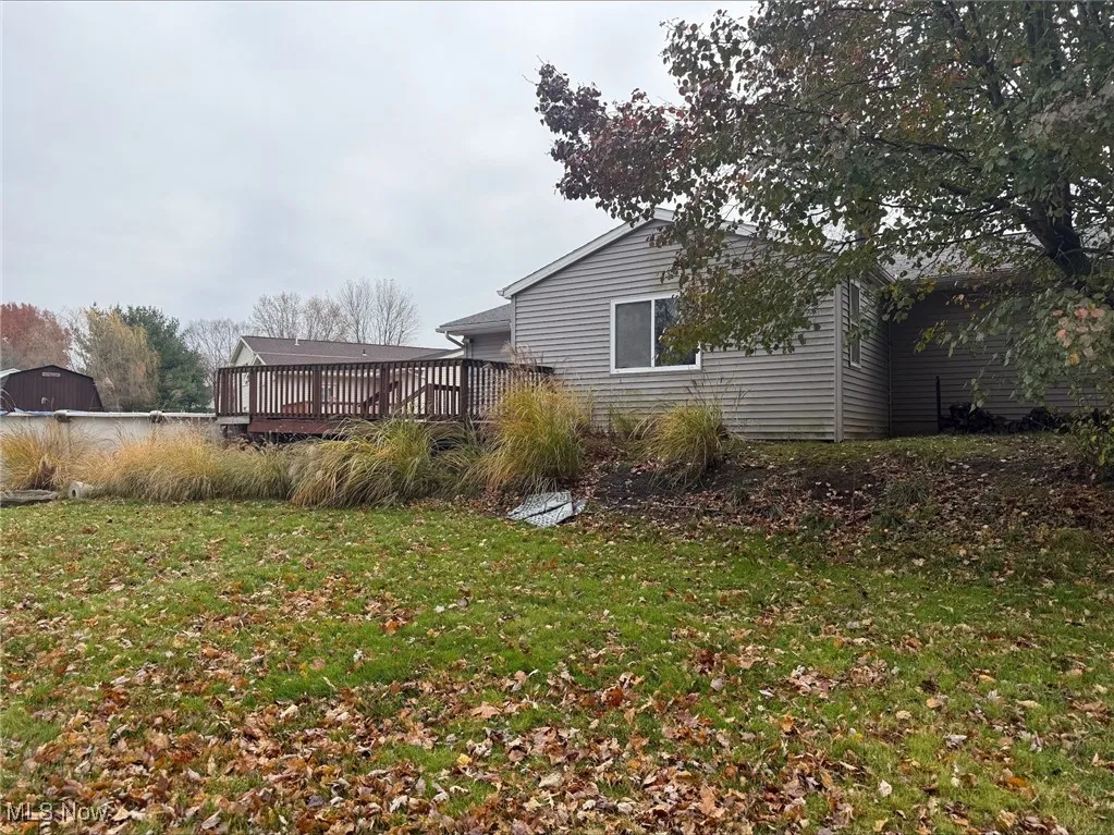 View of grassy yard featuring a wooden deck