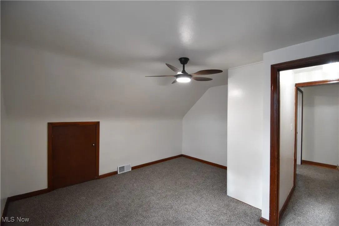 Bedroom featuring carpet, lofted ceiling, and a ceiling fan
