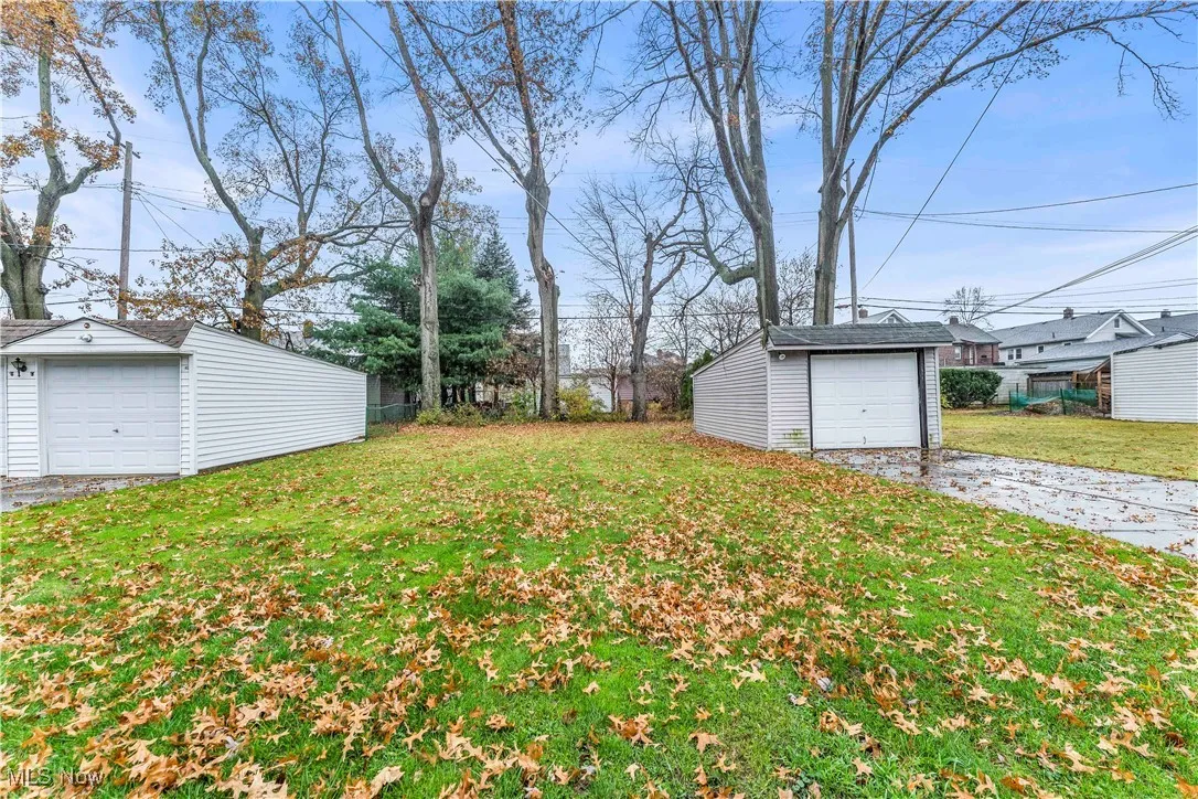 View of grassy yard featuring an outdoor structure and a garage