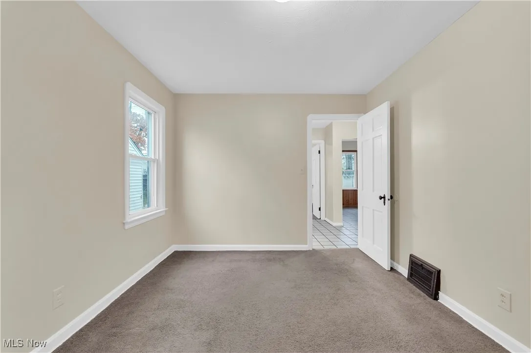 Spare room featuring carpet and baseboards