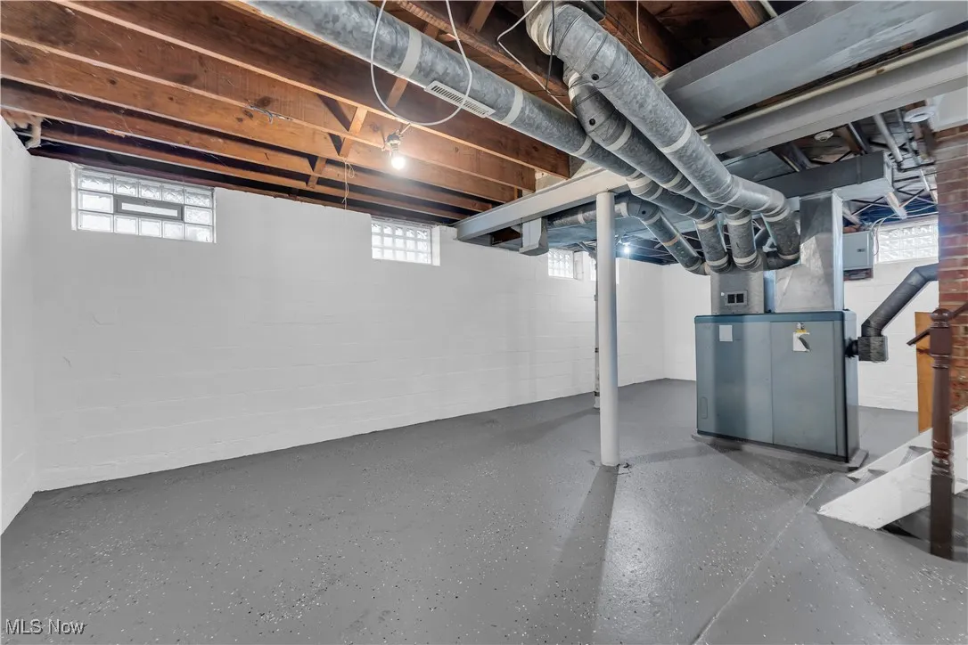 Basement featuring heating unit and plenty of natural light