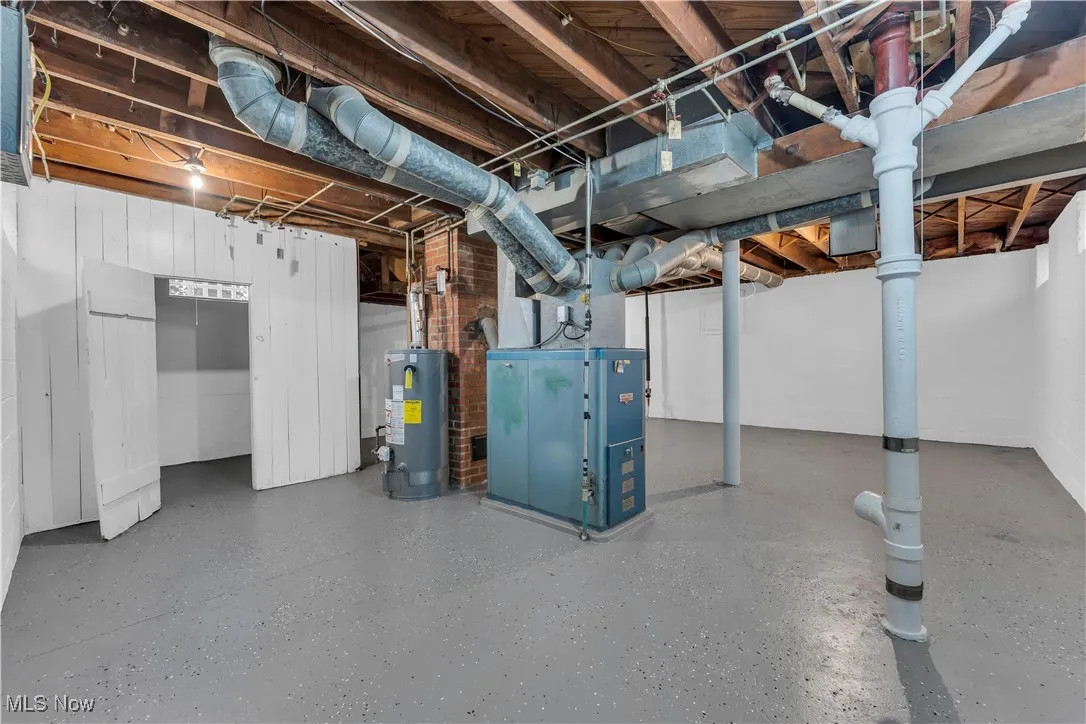 Unfinished basement featuring gas water heater and heating unit