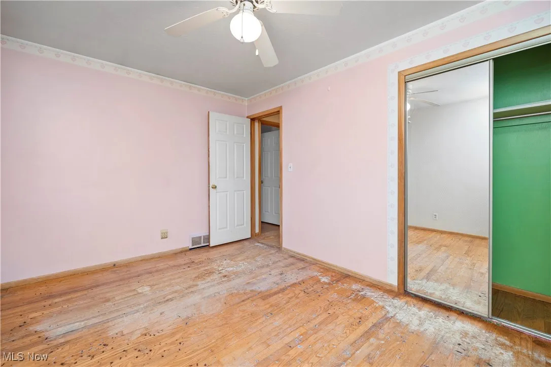 Unfurnished bedroom with light wood finished floors, a ceiling fan, and a closet