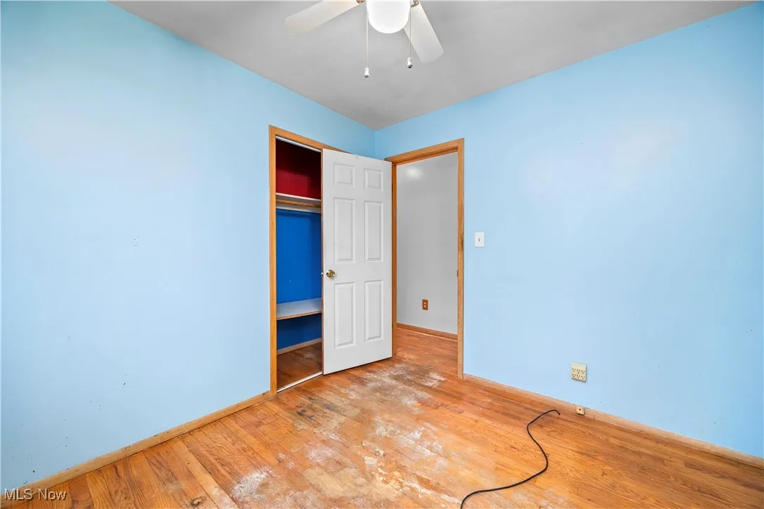 Unfurnished bedroom with hardwood / wood-style flooring, a closet, and ceiling fan