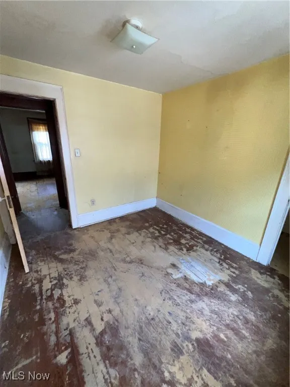 Spare room featuring baseboards