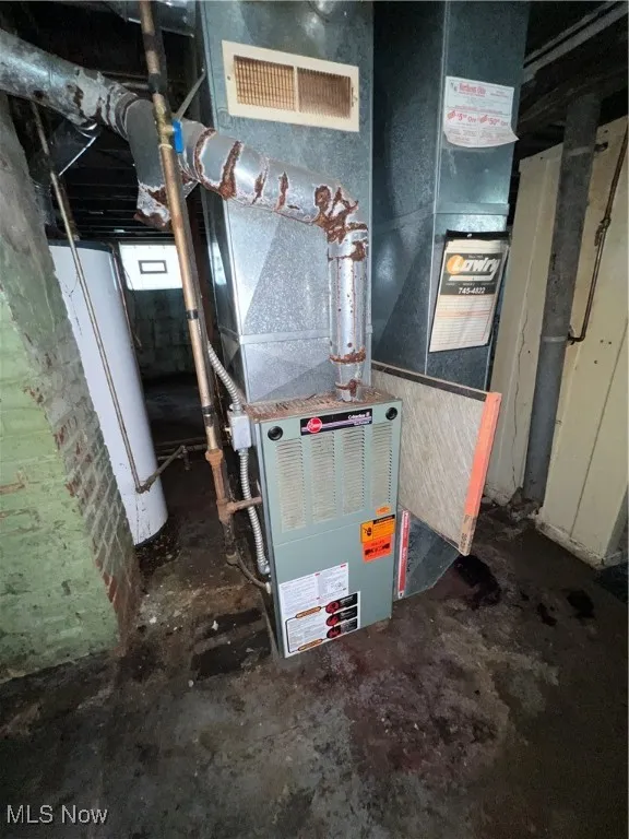 Utility room featuring water heater and heating unit
