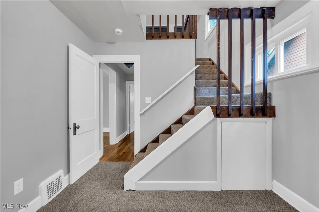 Staircase with carpet floors and baseboards