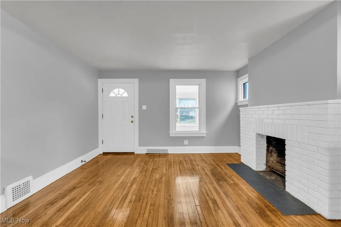Foyer with hardwood / wood-style floors and a brick fireplace