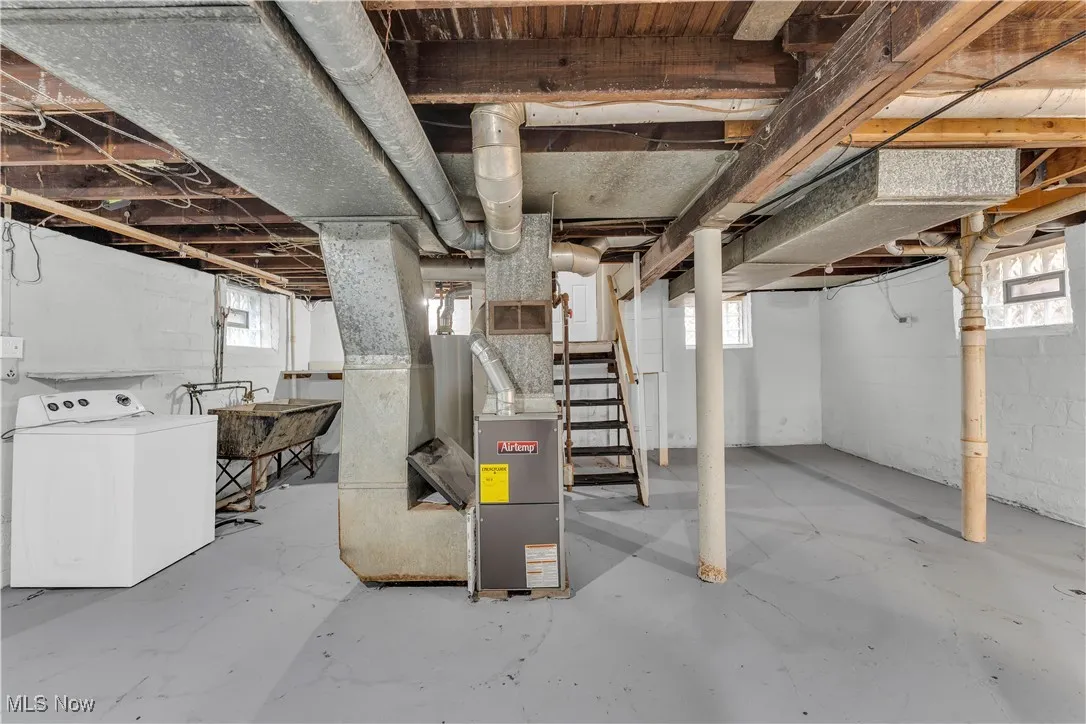 Basement with stairway, washer / dryer, heating unit, and plenty of natural light
