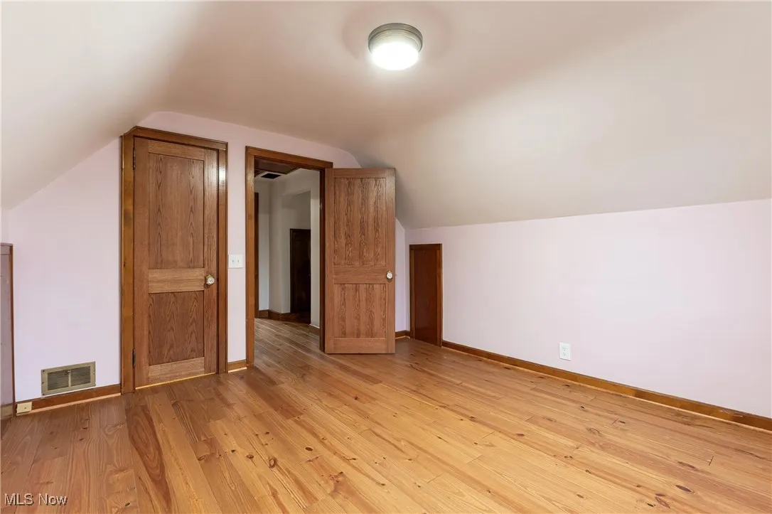 Additional living space with lofted ceiling and light wood-type flooring