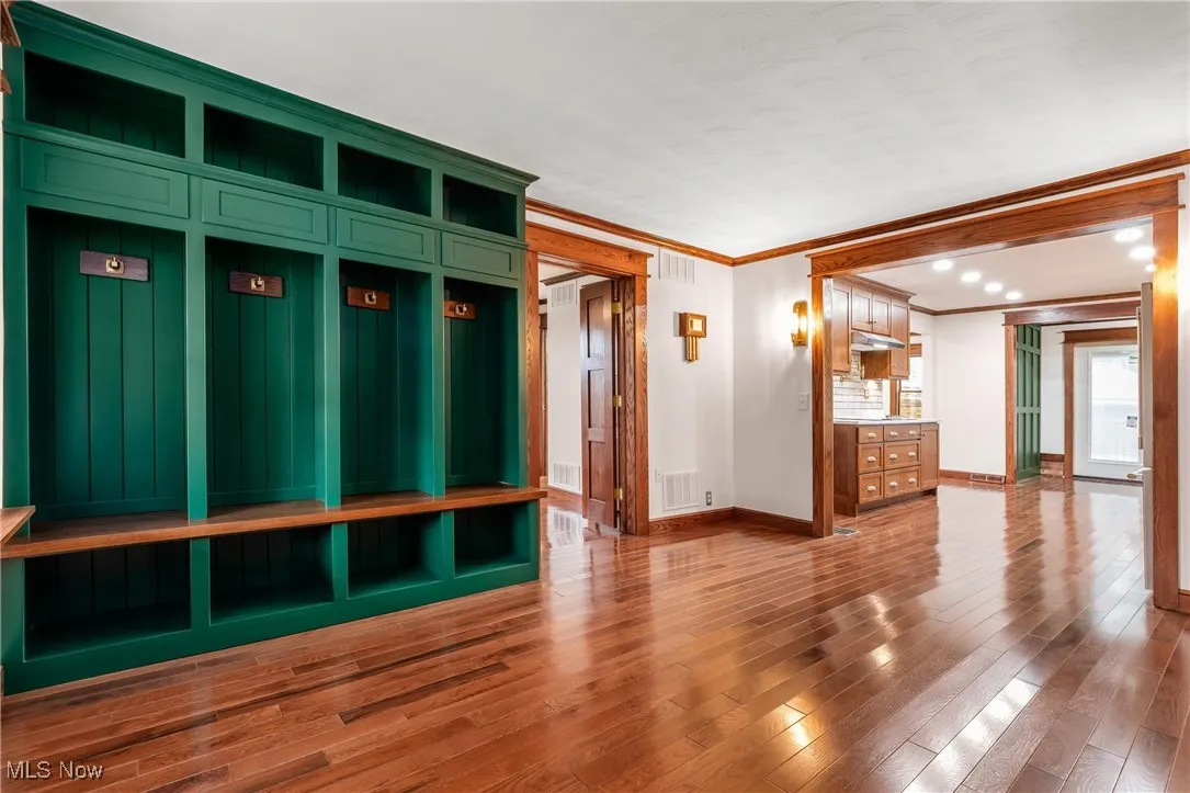 Mudroom featuring wood-type flooring, ornamental molding, and recessed lighting