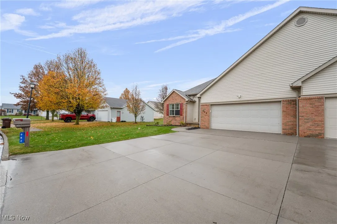 View of front facade with driveway, a front lawn, and brick siding