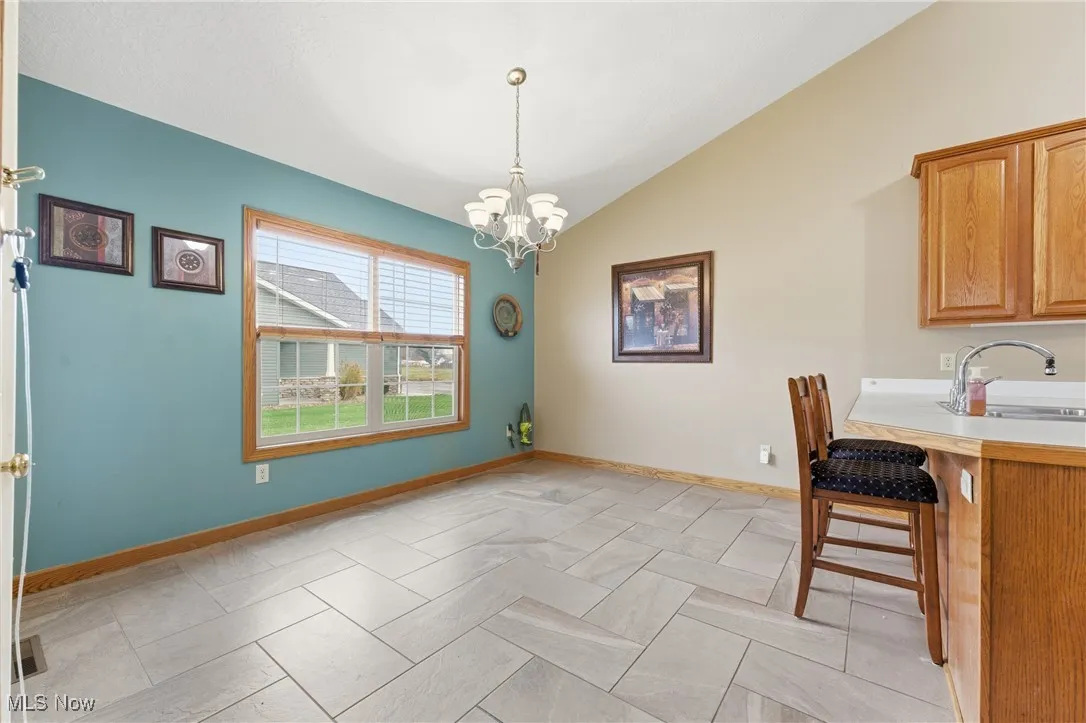 Dining space with vaulted ceiling and a chandelier
