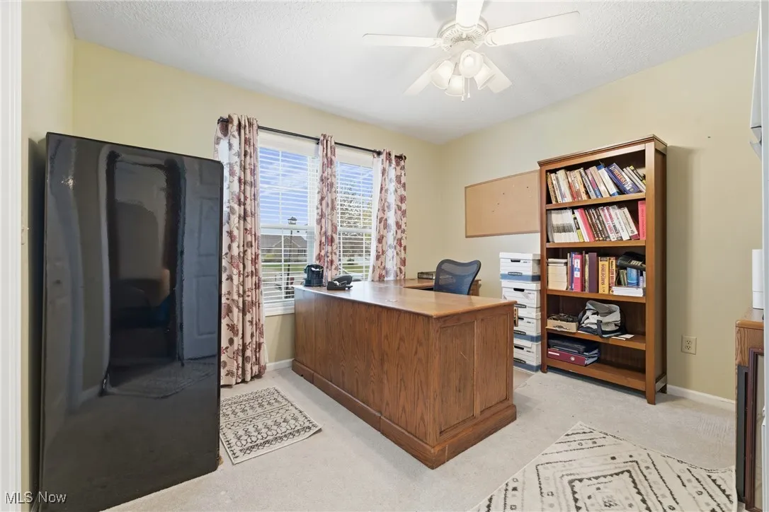 Bedroom area with light carpet, a textured ceiling, and a ceiling fan