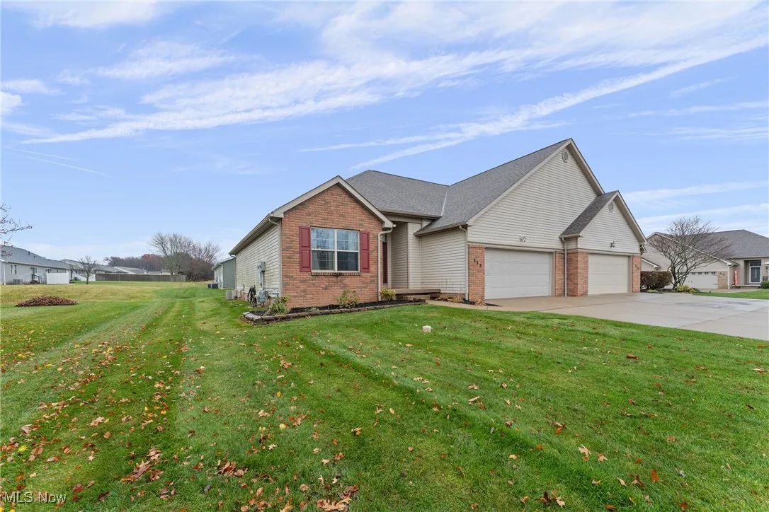 Ranch-style house featuring a front lawn, brick siding, driveway, and a garage