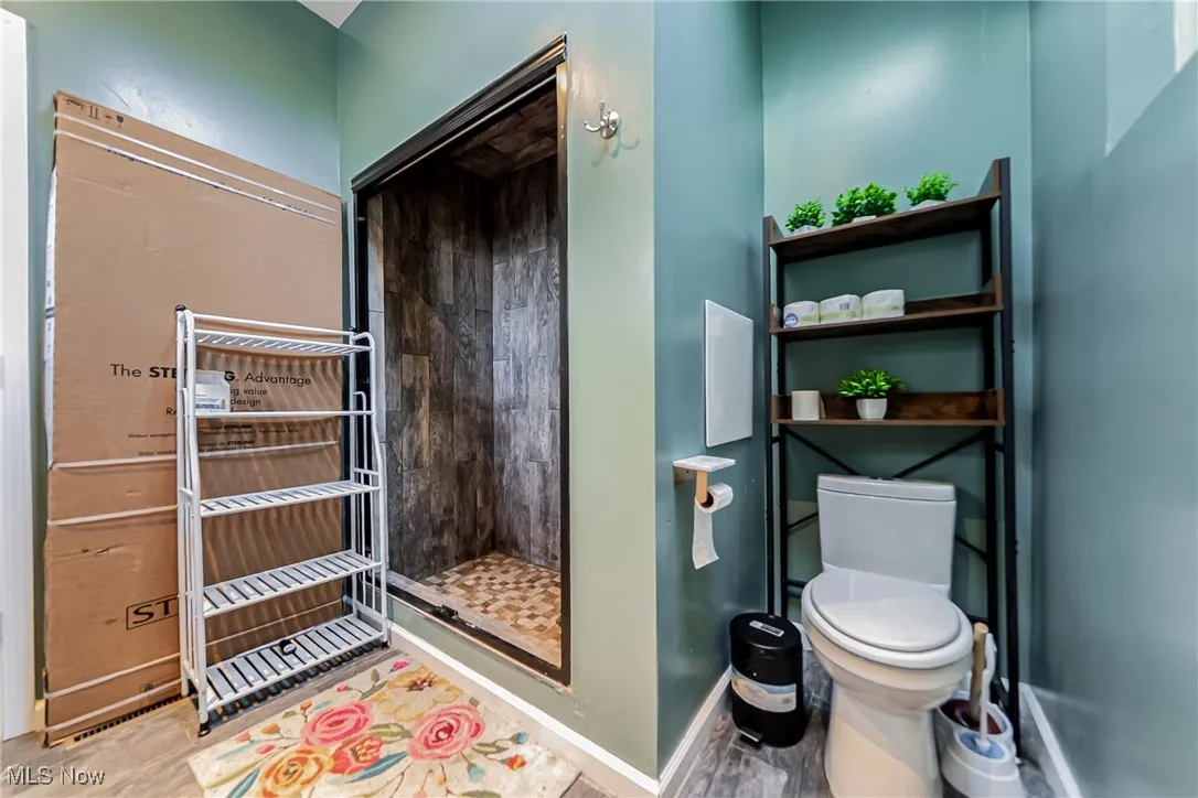 Bathroom with a shower stall and light wood-style floors