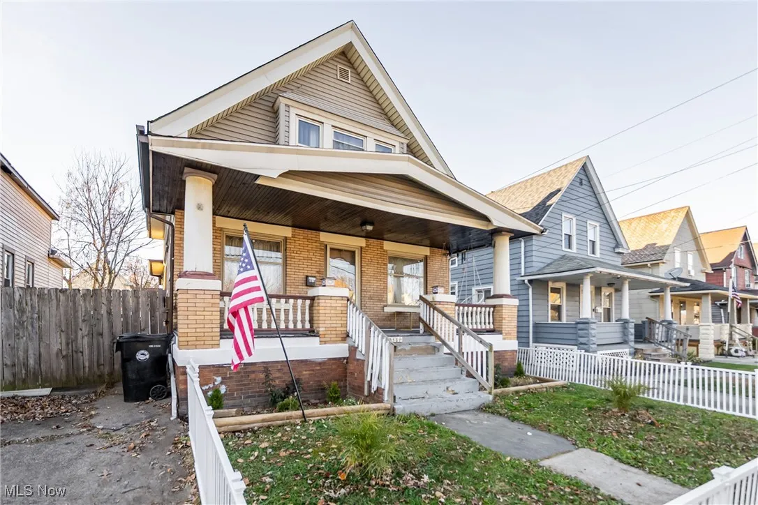 View of front of property with covered porch and brick siding