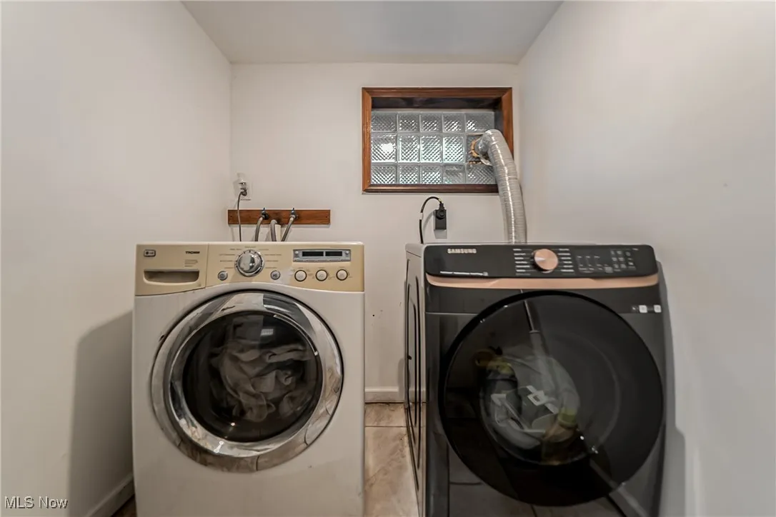 Laundry area featuring washer and dryer and tile patterned flooring