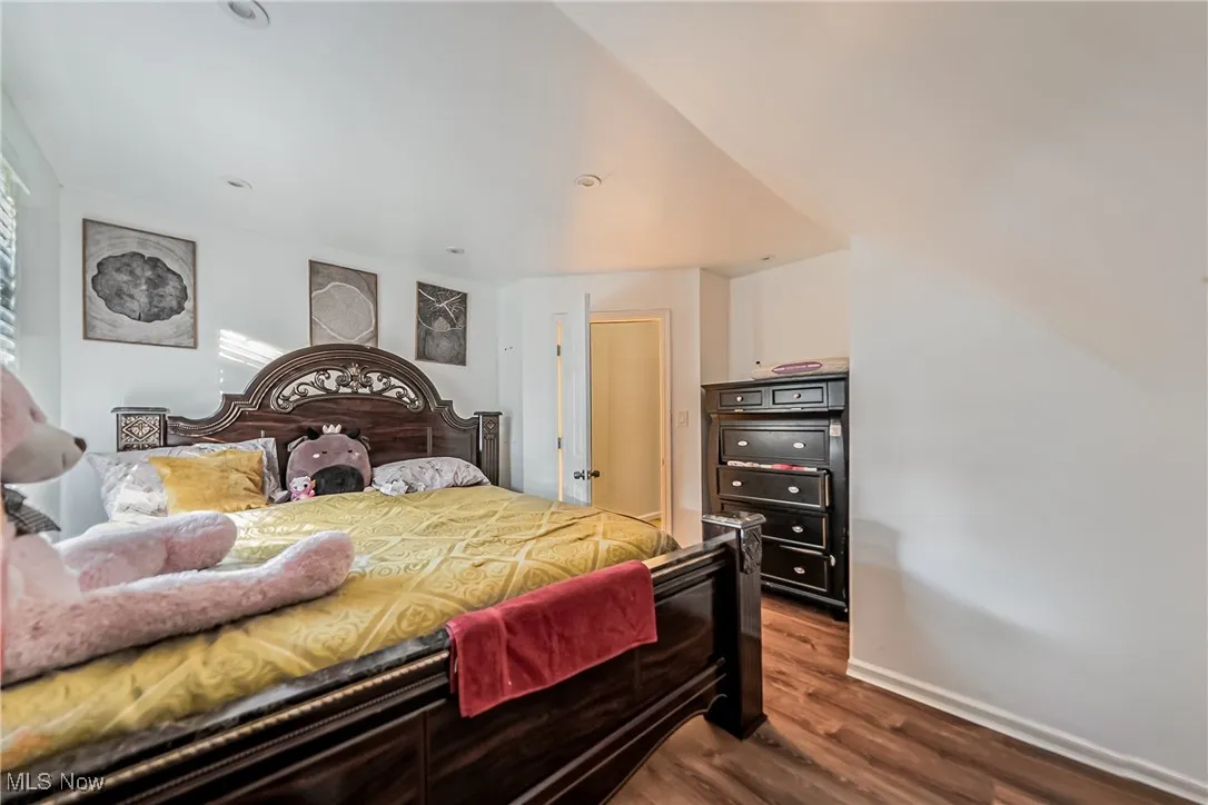 Bedroom with dark wood-type flooring and baseboards