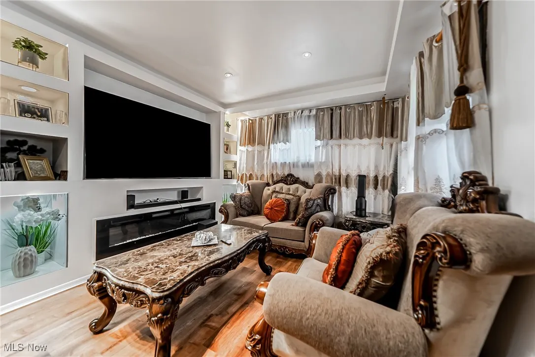 Living area featuring built in shelves and wood finished floors