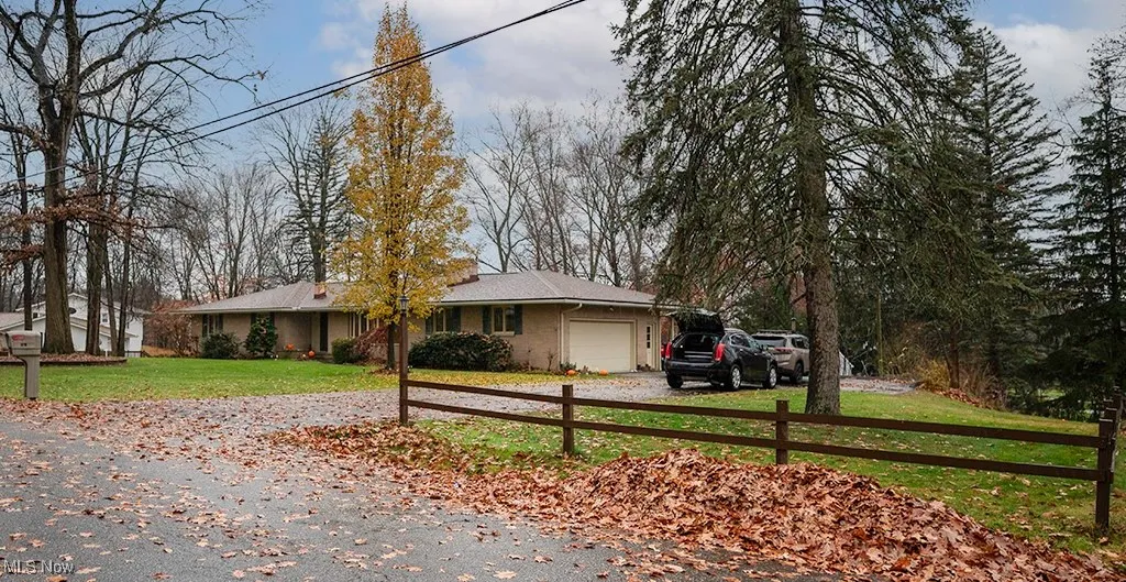 Ranch-style home featuring a front lawn, driveway, and an attached garage