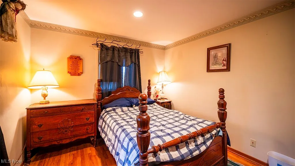Bedroom featuring wood finished floors and ornamental molding