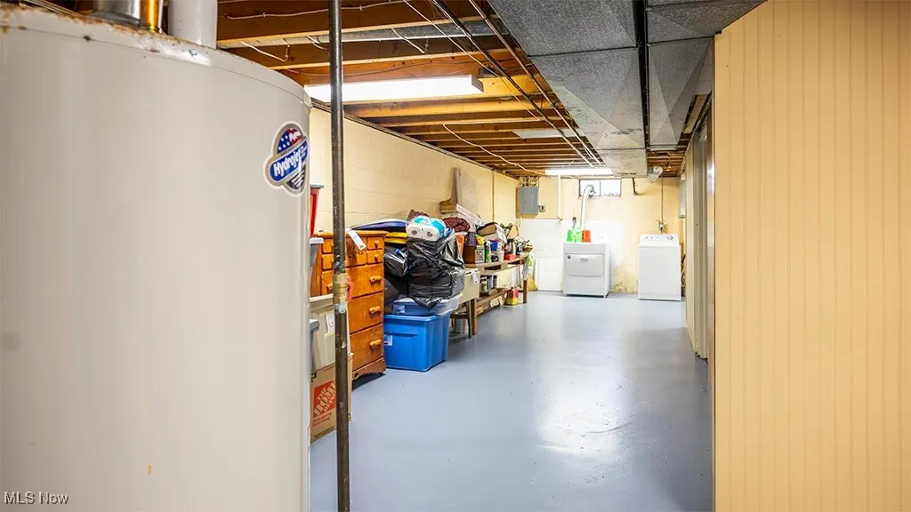 Unfinished below grade area with water heater and separate washer and dryer