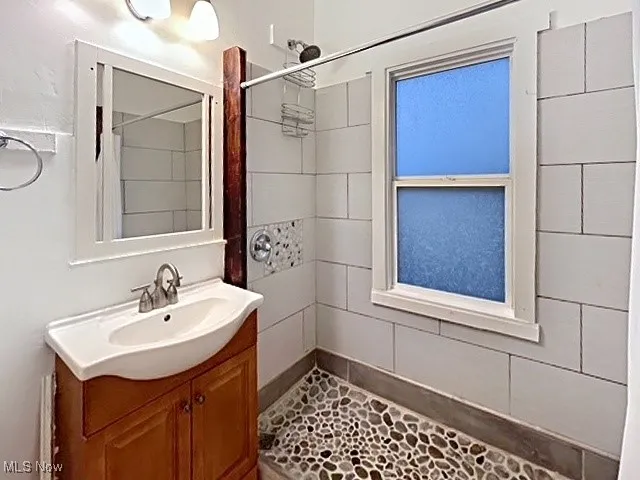 Full bathroom featuring a shower stall and vanity